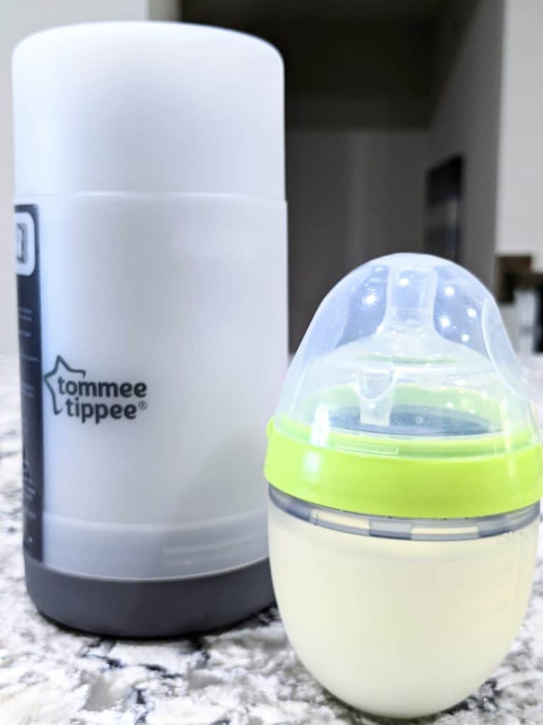 photo of baby bottle with milk and portable bottle warmer