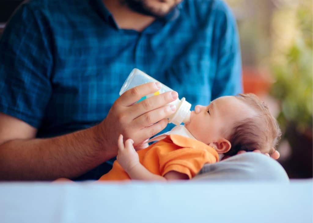 photo of dad feeding baby bottle of milk