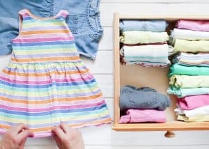 person folding clothes for a toddler girl's capsule wardrobe