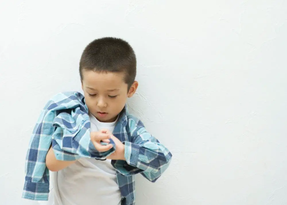 toddler trying to dress himself with capsule wardrobe