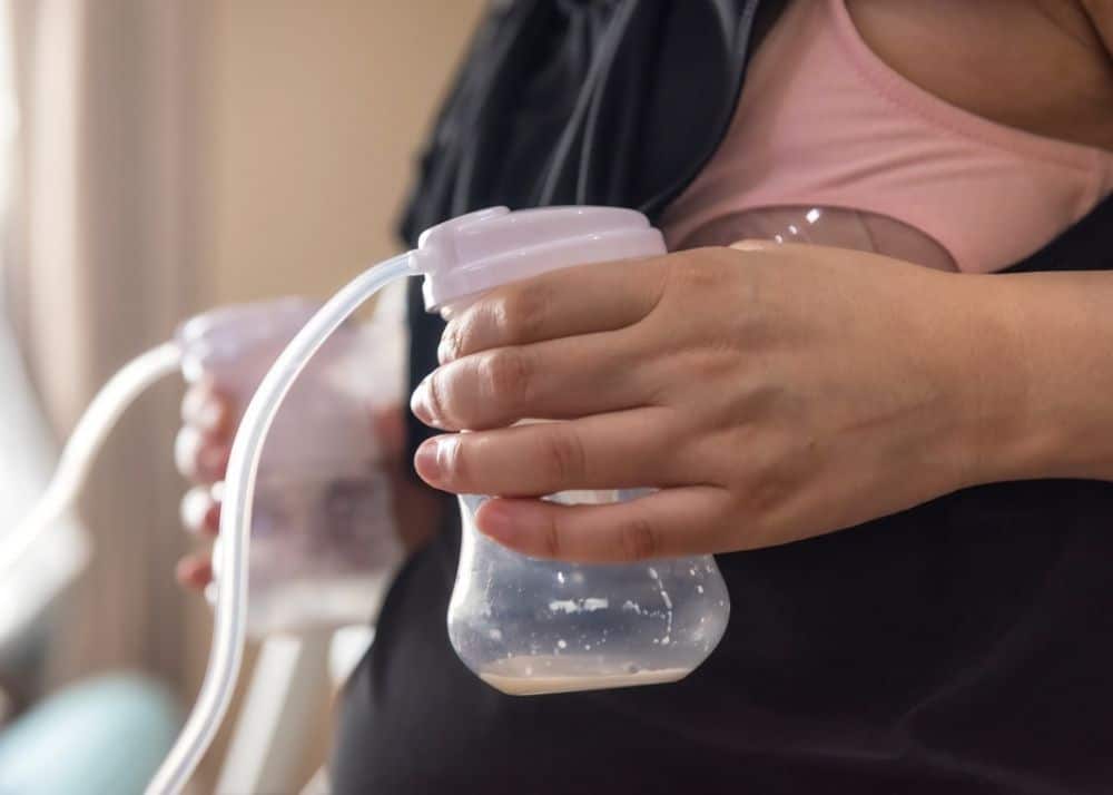 woman holding bottle while pumping