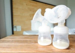 pump bottles on a wooden table with a little breast milk in them elastic nipples featured image