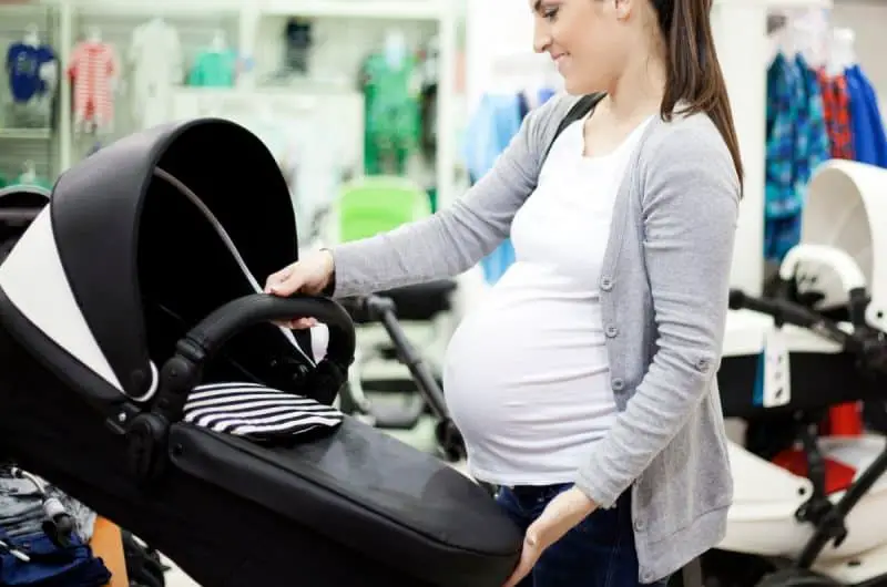 pregnant woman shopping for car seat and stroller