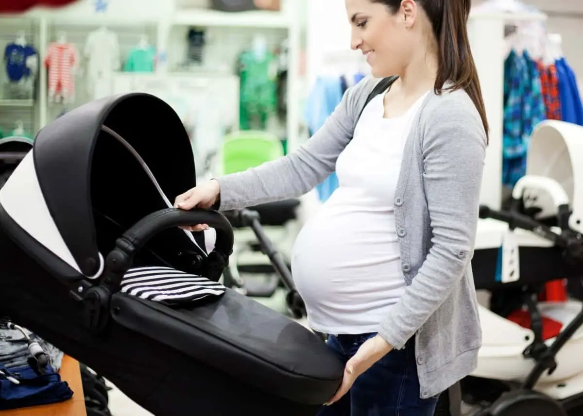 pregnant woman shopping for car seat and stroller