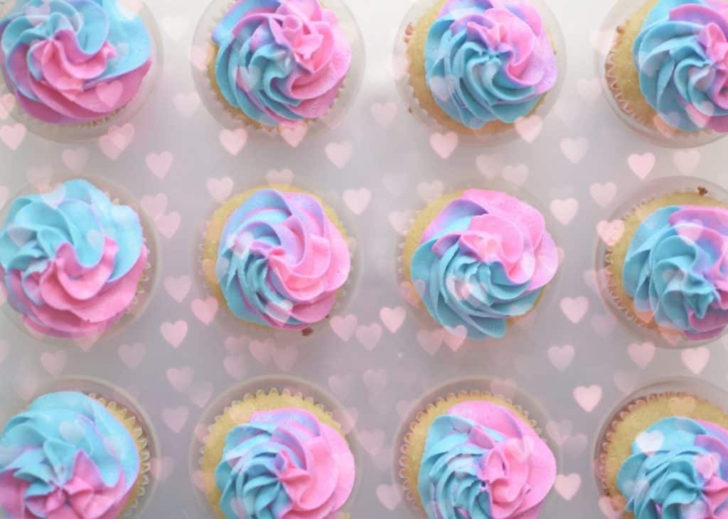 cupcakes with blue and pink swirled frosting for gender reveal