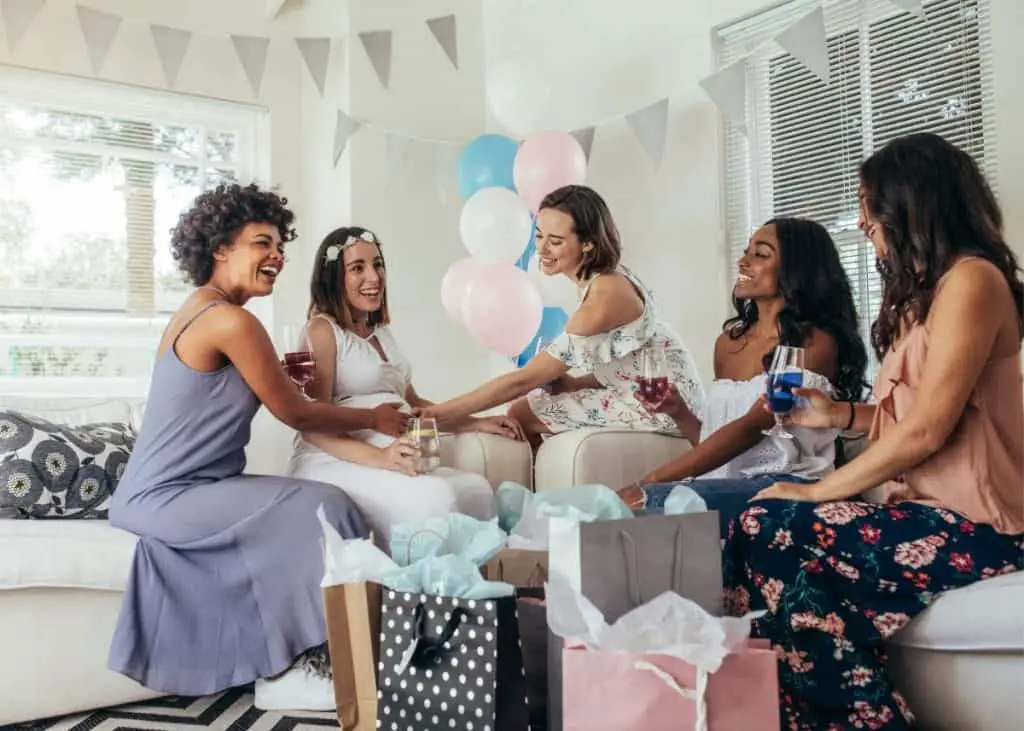 young women celebrating pregnant woman at baby shower