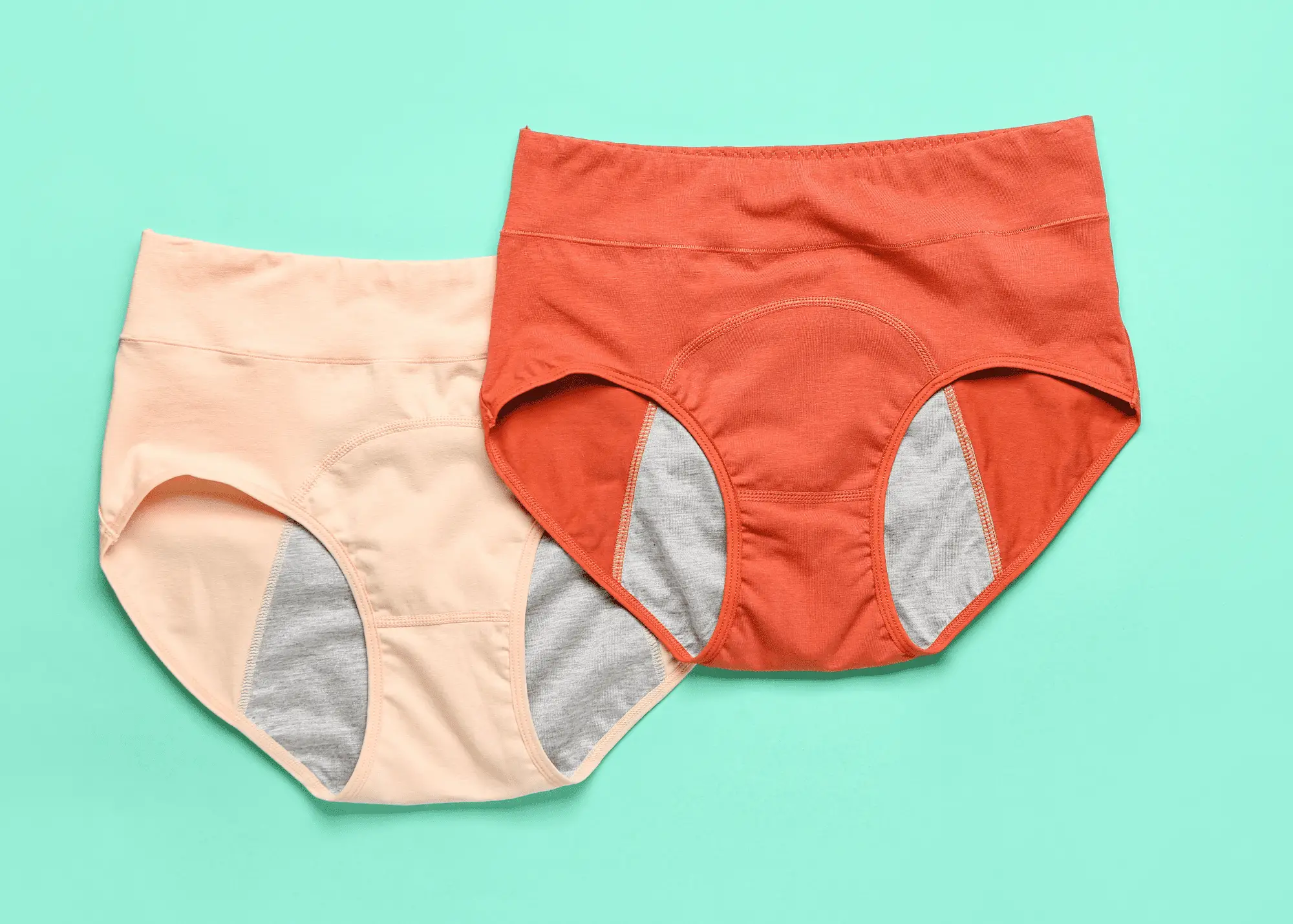 two pairs of period underwear on a green background