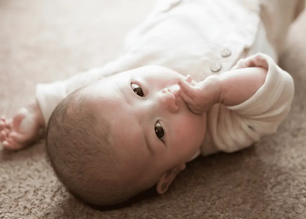 asian baby with slight eyebrows looking upside down