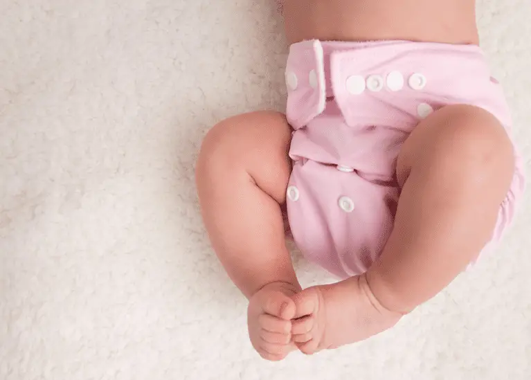 baby wearing a pale pink cloth diaper