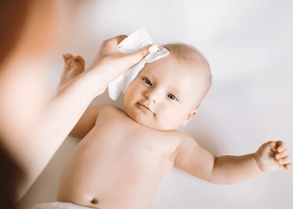 mom wiping baby's eyebrows and forehead to care for eyebrows
