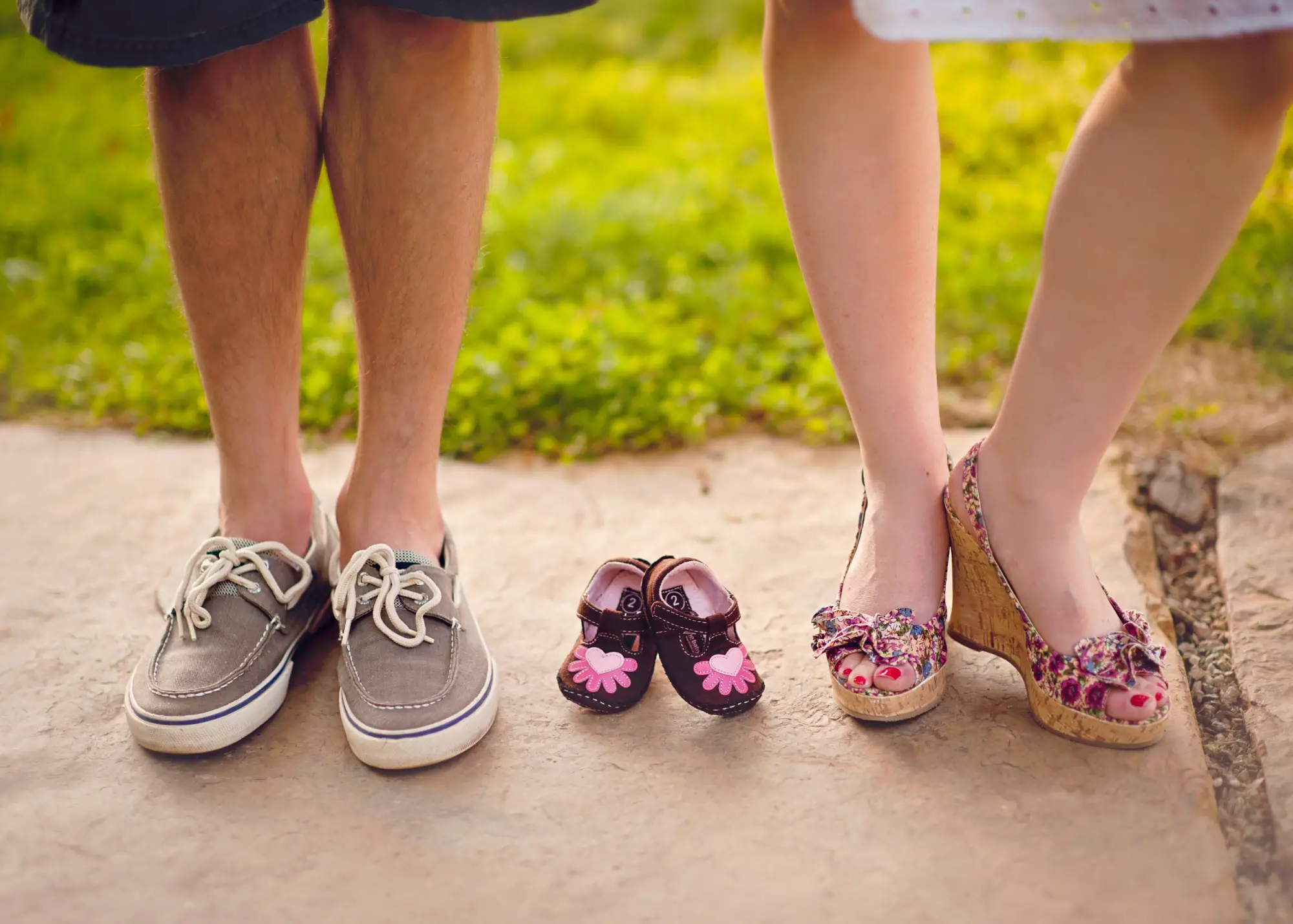 photo of new dad and mom and baby shoes as a sneaky way to announce pregnancy