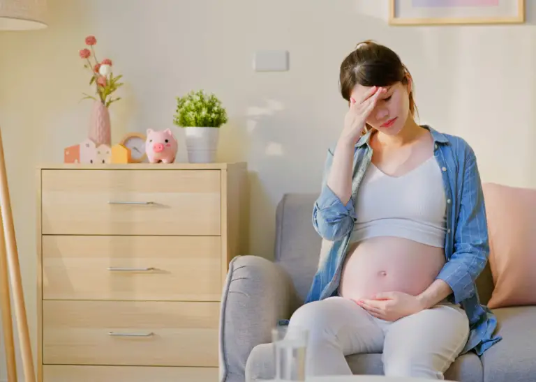 pregnant woman feeing overwhelmed while holding pregnancy bump