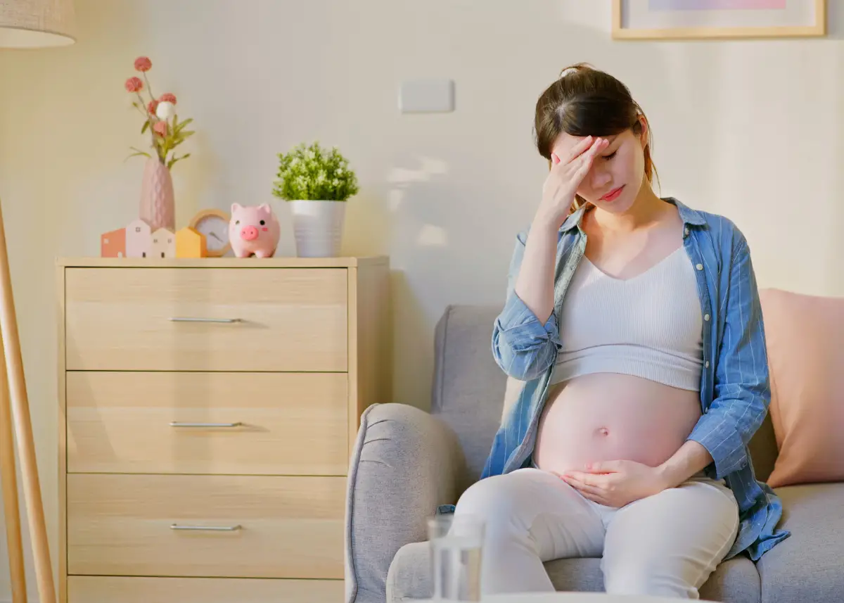 pregnant woman feeing overwhelmed while holding pregnancy bump