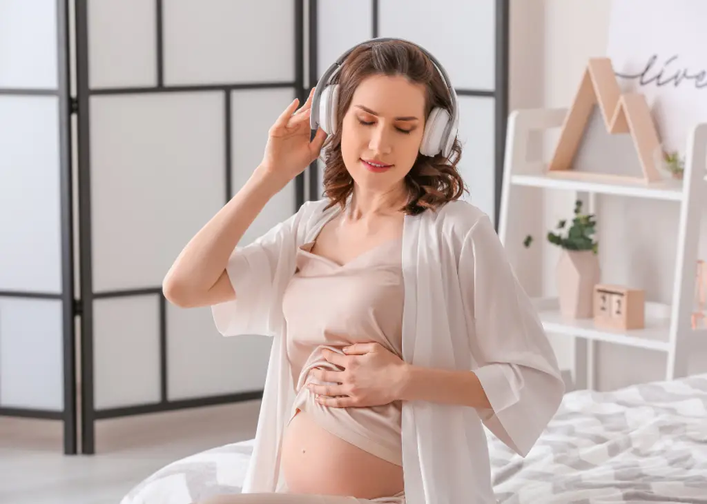 pregnant woman who is listening to hypnobirthing affirmations to prepare for birth