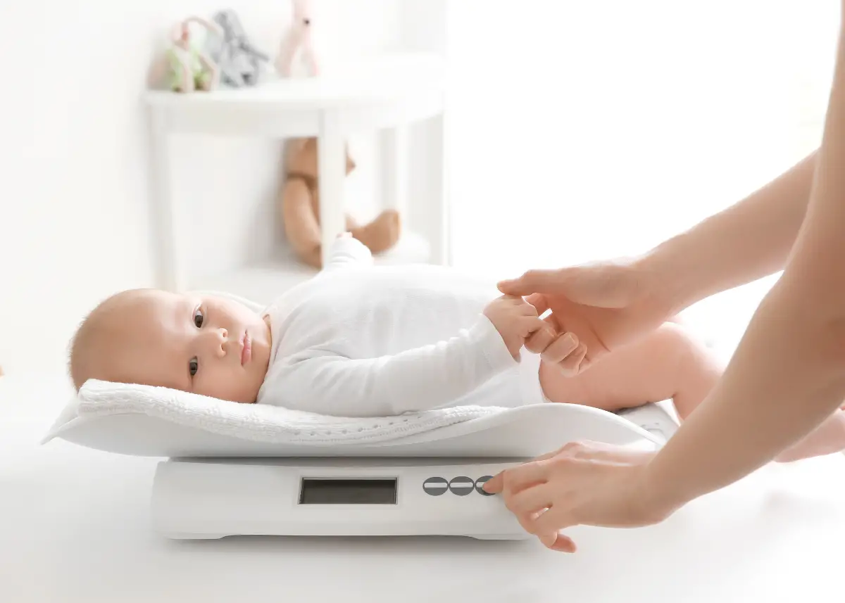 mom weighing her baby at home with a baby scale
