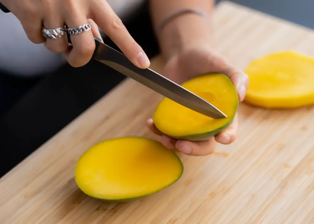 mom cutting a ripe mango to serve to her baby during baby-led weaning