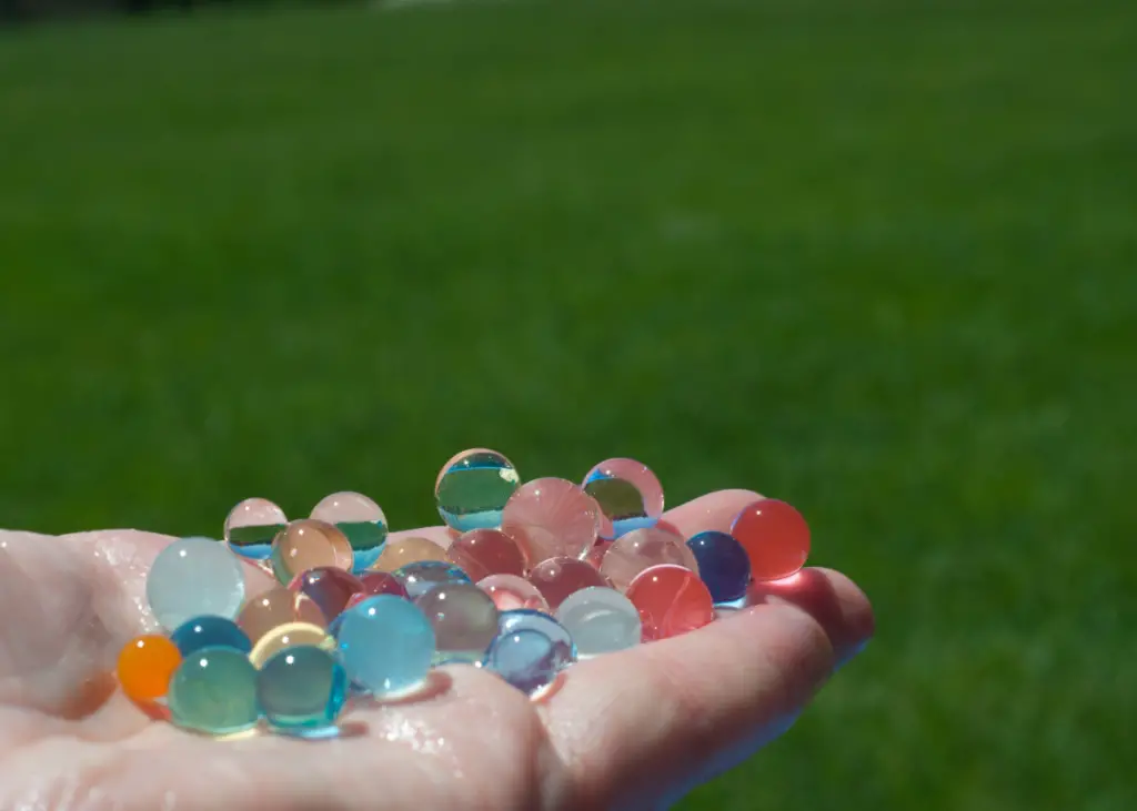 person holding multi-colored Orbeez water beads