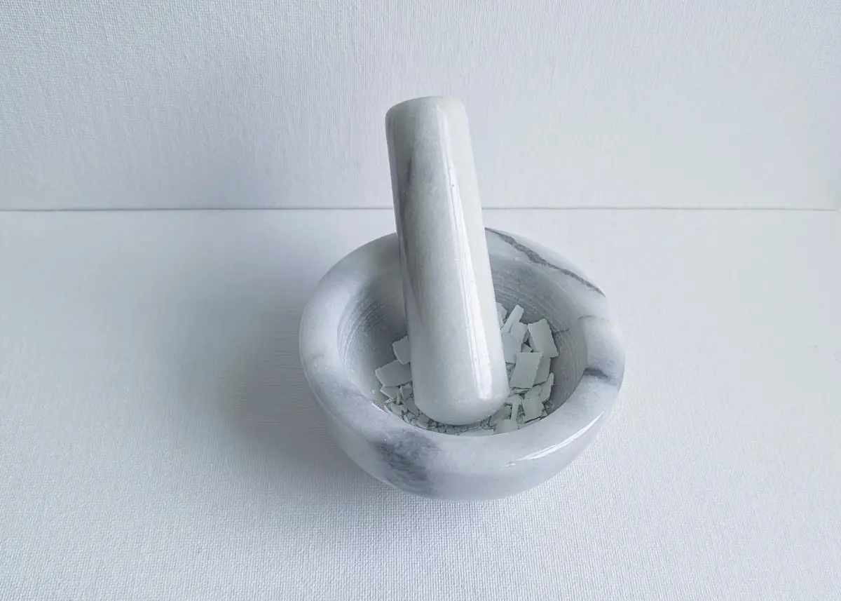 using mortar and pestle to make breast milk jewelry with preservation powder