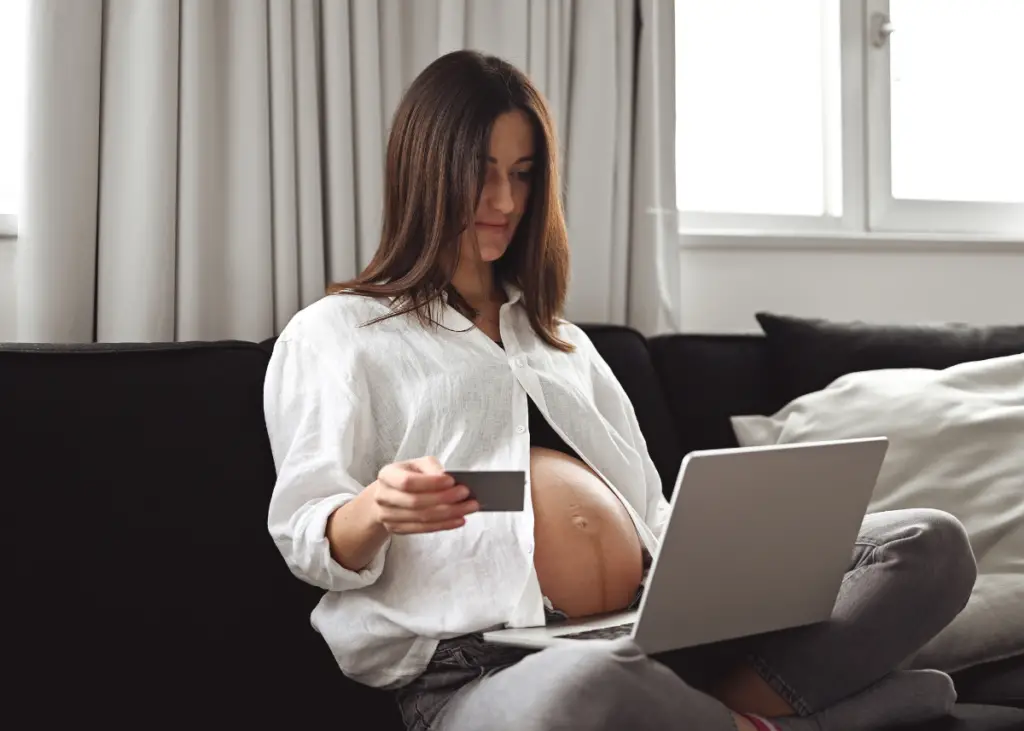 pregnant woman shopping on a laptop for maternity clothes